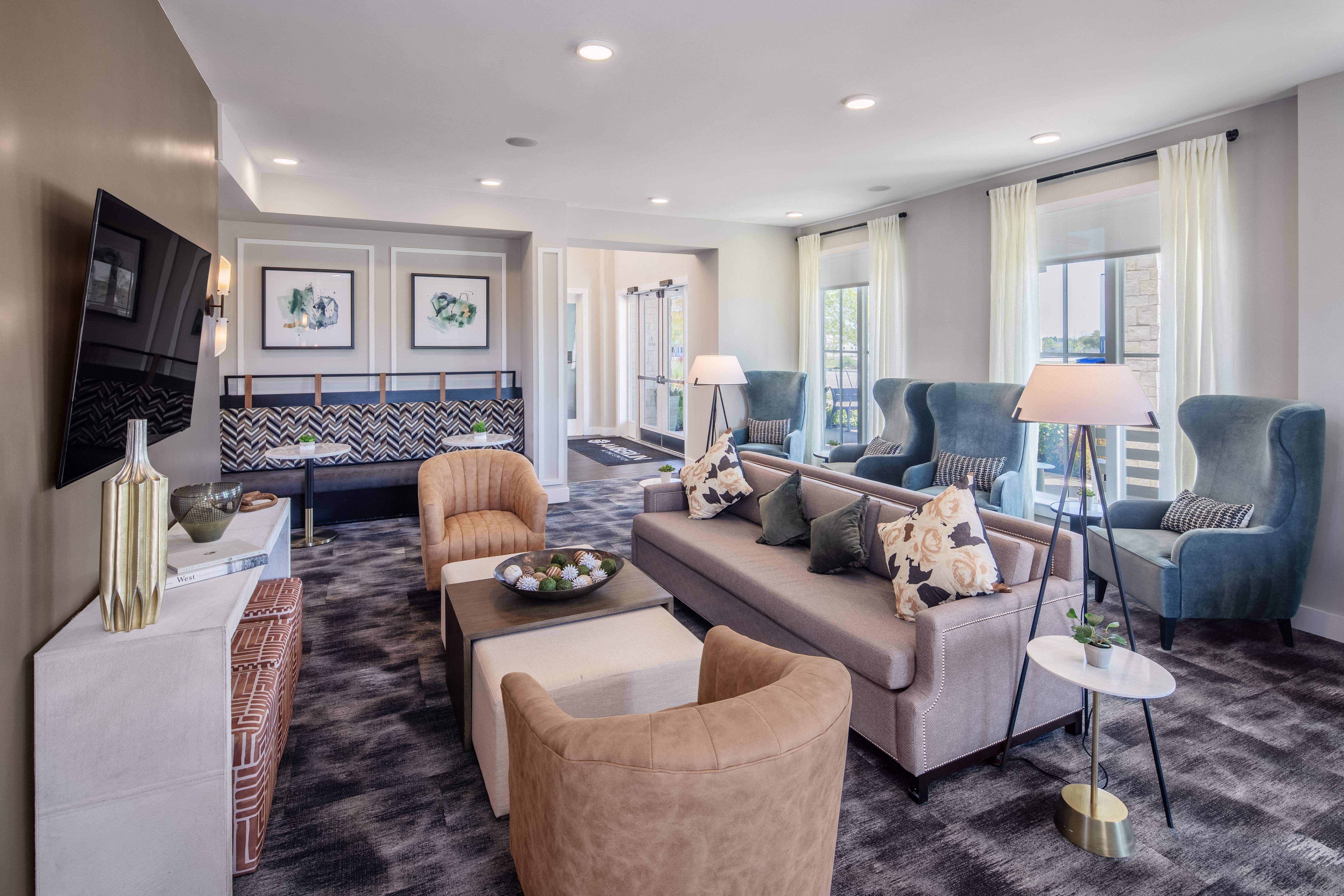 an open living room with couches and chairs at a senior apartment community